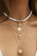 Gold-tone multi-layer necklace with shell and starfish pendants in a boho coastal style