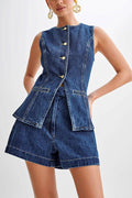 Woman in fitted dark-wash sleeveless denim vest with gold buttons and high-waisted denim shorts