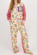 Woman in cream satin shirt and wide-leg pants set with red origami-crane and floral lucky-charm print
