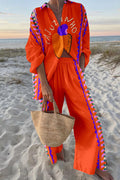 Woman in a bright orange cashew-graphic linen shirt and wide-leg pants set with zigzag trim