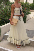 Model in a white ruffled lace cami top and flowing maxi skirt two-piece set