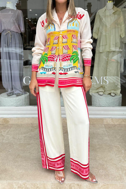 Model in a cream resort-print long-sleeve shirt and wide-leg pants set with red side borders