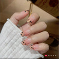 Sheet of gold-glitter French-tip gel nail wraps with black leopard spots and pale-blue dots