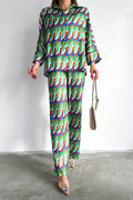 Model in retro geometric wave-print co-ord set in green, blue and orange, long-sleeve shirt and wide-leg pants