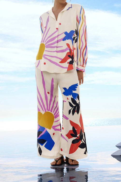 Model wearing a multicolor sleeveless halter-neck top with matching pants as a two-piece vacation set